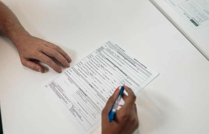 Two people reviewing and signing adoption documents, symbolizing legal procedures and family planning.