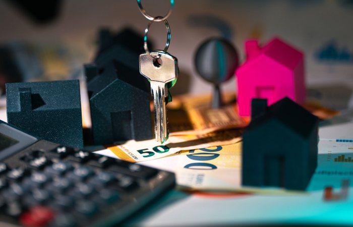 A symbolic representation of real estate finance featuring keys, model houses, and euro banknotes.