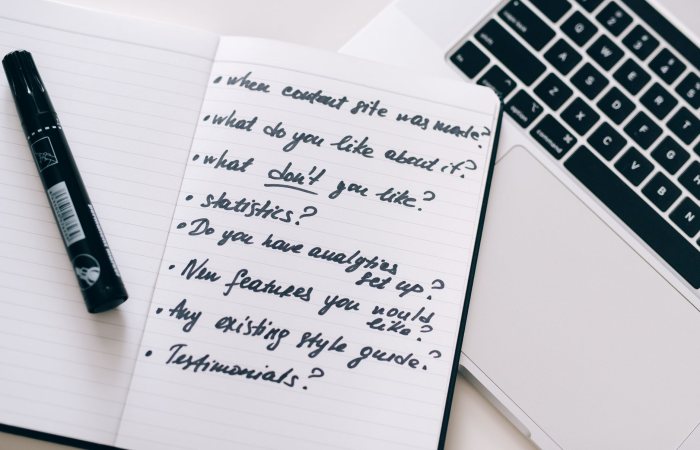 Close-up of a notebook with handwritten notes next to a laptop, ideal for business or educational content.